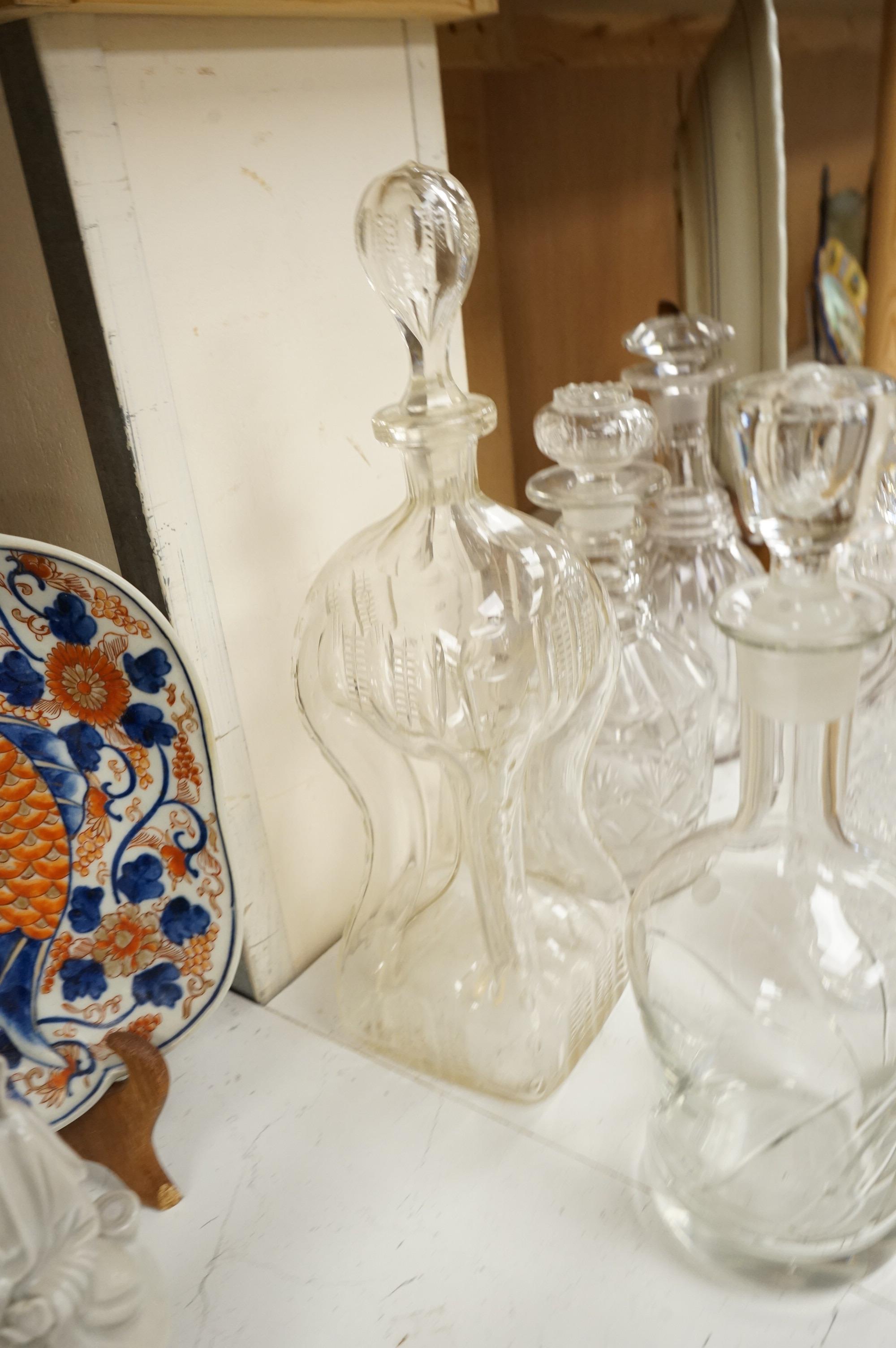 Six 19th century and later cut glass decanters and stoppers, one with white metal acorn design collar, largest 37cm high